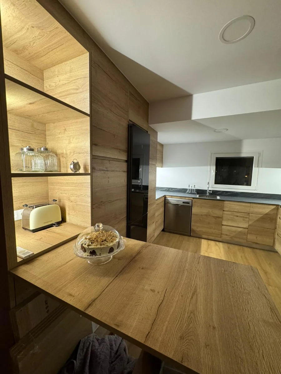 Cocina en madera natural con detalles negros en Vic